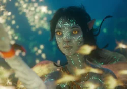 Kiri underwater surrounded by bioluminescent sea life in Avatar: The Way of Water